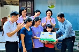 Ông Ngô Công Thắng - Giám đốc Nhà máy sữa Vinamilk Nghệ An đại diện công ty và Quỹ sữa Vươn cao Việt Nam thăm hỏi gia đình và trao tặng học bổng trị giá 50 triệu đồng để hỗ trợ chị em Đạt. (Nguồn: Vietnam+)