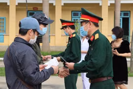 Lãnh đạo Bộ Chỉ huy quân sự tỉnh Hòa Bình trao giấy chứng nhận hoàn thành thời gian cách ly cho công dân. (Ảnh: Thanh Hải/TTXVN)