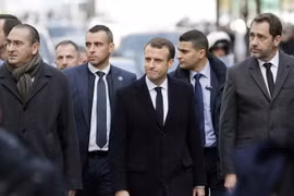 Tổng thống Pháp Emmanuel Macron (giữa) tới khu vực Khải Hoàn Môn ở thủ đô Paris để xem xét những thiệt hại do những đối tượng biểu tình quá khích gây ra. (Nguồn: AFP/TTXVN)
