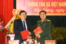 Giám đốc Truyền hình Thông tấn Nguyễn Thiện Thuật và Thượng tá Nguyễn Thành Phố, Sư đoàn trưởng Sư đoàn 325 ký biên bản kết nghĩa. (Ảnh: Dương Giang/TTXVN)