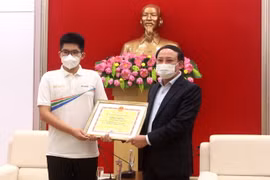 Ông Nguyễn Xuân Ký, Bí thư Tỉnh ủy Quảng Ninh tặng bằng khen cho Nguyễn Hoàng Khánh, nhà vô địch Đường lên đỉnh Olympia năm 2021. (Ảnh: Thanh Vân/TTXVN)