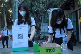 Học sinh Trường THPT Lê Quý Đôn (quận 3) khai báo y tế ở khu vực ngoài cổng trường. (Ảnh: Thu Hoài/TTXVN)