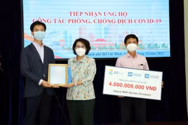Bà Tô Thị Bích Châu, Chủ tịch Ủy ban MTTQ Việt Nam Thành phố Hồ Chí Minh (giữa) trao thư cảm ơn các doanh nghiệp Hàn Quốc đã ủng hộ công tác phòng, chống dịch COVID-19. (Ảnh: Xuân Khu/TTXVN)