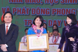 Phó Chủ tịch nước Đặng Thị Ngọc Thịnh và Bộ trưởng Bộ Giáo dục và Đào tạo Phùng Xuân Nhạ trao bằng khen cho các giáo viên, học sinh. (Ảnh: Quý Trung/TTXVN)