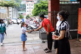 Các trường học thực hiện việc sát khuẩn tay cho học sinh, phụ huynh khi đến trường. (Ảnh: Hữu Quyết/TTXVN)