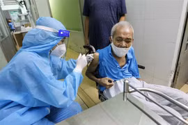 Các y bác sỹ bệnh viện Phú Nhuận thực hiện tiêm vaccine cho người trên 65 tuổi, người có bệnh nền tại Trung tâm y tế phường 11, quận Phú Nhuận. (Ảnh: Thanh Vũ/TTXVN)