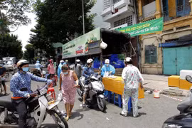 Trước thông tin giãn cách xã hội mới, nhiều người dân thành phố tranh thủ mua hàng hóa bình ổn giá trên đường Tháp Mười (Quận 6). (Ảnh: Thanh Vũ/TTXVN)