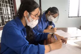 Em Vi Thị Hồng (19 tuổi, xã Đăk Hring, huyện Đăk Hà, tỉnh Kon Tum) viết đơn xung phong hỗ trợ tuyến đầu chống dịch COVID-19. (Ảnh: Khoa Chương/TTXVN)