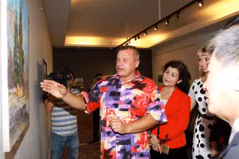 Họa sĩ Mikhail Vyacheslavovich Stoyachko giới thiệu với các đại biểu về tranh "Phong cảnh nước Nga" tại triển lãm. (Ảnh: Thanh Vũ/TTXVN)