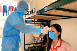 Đo thân nhiệt cho người dân trong khu cách ly. 