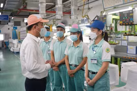 Tổng Giám đốc Bảo hiểm xã hội Việt Nam Nguyễn Thế Mạnh kiểm tra việc hỗ trợ người lao động tại Công ty ToTo Việt Nam. (Ảnh: PV/Vietnam+)