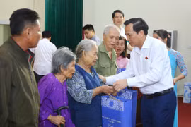 Bộ trưởng Đào Ngọc Dung trao tặng quà cho các gia đình chính sách, người có công. (Ảnh: PV/Vietnam+)