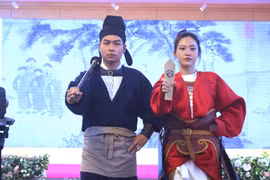 Hai trang phục phỏng dựng thời Trần có sử dụng phụ kiện như kiếm và lệnh bài. (Ảnh: Minh Anh/Vietnam+)