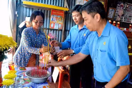 Phó Chủ tịch Liên đoàn Lao động tỉnh An Giang Nguyễn Hữu Giang (bìa phải) thắp hương chia buồn cùng gia đình nạn nhân Nguyễn Văn Út. (Ảnh: Công Mạo/TTXVN)