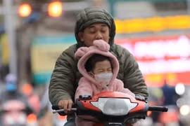 Người dân đã phải mặc ấm khi ra đường. (Ảnh: Thanh Tùng/TTXVN)