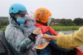 Một gia đình từ tỉnh Bình Dương được hỗ trợ phần cơm và trái cây miễn phí khi lưu thông qua tỉnh Phú Yên. (Ảnh: Phạm Cường/TTXVN)