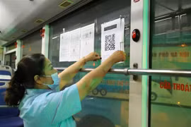 Dán mã QR tại bến xe để hành khách thực hiện khai báo y tế. (Ảnh: Hoàng Hiếu/TTXVN)