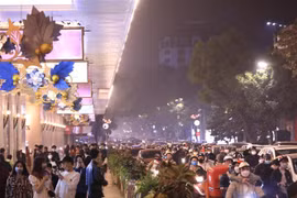 Người và phương tiện trên tuyến phố Hàng Bài hướng về khu vực Hồ Gươm trong đêm Noel. (Ảnh: Hoàng Hiếu/TTXVN)