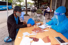 Người dân phải khai báo y tế, test nhanh COVID-19 khi đến khu vực ngõ 587, đường Trần Nhân Tông, phường Vị Hoàng, thành phố Nam Định. (Ảnh: Nguyễn Lành/TTXVN)