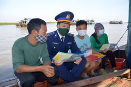 Thượng tá Nguyễn Văn Hiển tuyên truyền IUU cho bà con ngư dân Đồ Sơn. (Ảnh: TTXVN phát)