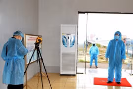 Tiến hành đo thân nhiệt, khai báo y tế đối với cán bộ nhân viên, lái xe, công nhân tại cửa khẩu quốc tế Móng Cái, thành phố Móng Cái. (Ảnh: Bùi Đức Hiếu/TTXVN)
