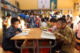 Học sinh tại điểm trường Bản Xèo, huyện Bát Xát đọc sách do Đoàn Thanh niên Thông tấn xã Việt Nam trao tặng. (Ảnh: Quốc Khánh/TTXVN)