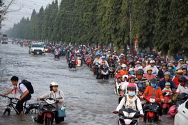 Đường Nguyễn Văn Cừ, quận Ninh Kiều bị ngập sâu, người dân gặp nhiều khó khăn khi di chuyển qua đây. (Ảnh: Thanh Liêm/TTXVN)