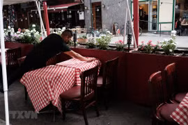Nhân viên sửa soạn lại bàn ghế tại một nhà hàng ở New York, Mỹ. (Ảnh: AFP/TTXVN)
