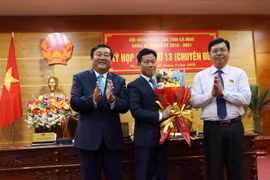 Tân Phó Bí thư Tỉnh uỷ, Chủ tịch UBND tỉnh Cà Mau Lê Quân nhận hoa chúc mừng từ Bí thư Tỉnh ủy Nguyễn Tiến Hải và Chủ tịch HĐND tỉnh Trần Văn Hiện. (Ảnh: Kim Há/TTXVN)