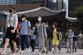 Người dân đeo khẩu trang phòng lây nhiễm COVID-19 tại Seoul, Hàn Quốc. (Ảnh: AFP/TTXVN)