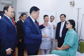 Trưởng Ban Tuyên giáo Trung ương Nguyễn Trọng Nghĩa thăm hỏi, tặng quà cho bệnh nhân đang điều trị tại Bệnh viện Thể thao Việt Nam. (Ảnh: Minh Quyết/TTXVN)