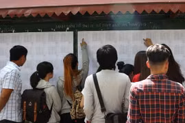 Thí sinh xem số báo danh và phòng thi tại điểm thi trường THPT chuyên Quốc học Huế. (Ảnh: Tường Vi/TTXVN)