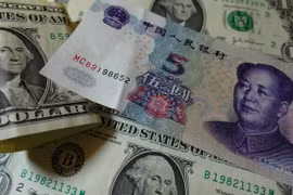 Đồng USD (trái) và nhân dân tệ (phải). (Nguồn: AFP/TTXVN)