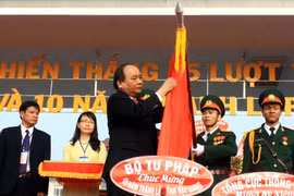 Phó thủ tướng Nguyễn Xuân Phúc gắn Huân chương Độc lập hạng Nhì lên lá cờ truyền thống tỉnh Hậu Giang. (Ảnh: Duy Khương/TTXVN)