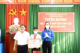 Tỉnh đoàn Hà Tĩnh trao tặng Bằng khen cho em Nguyễn Văn Dương vì đã có hành động dũng cảm cứu bạn nhỏ khỏi đuối nước. (Ảnh: Hoàng Ngà/TTXVN)