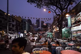 Khách du lịch nước ngoài và người dân địa phương thăm tuyến phố du lịch nổi tiếng Jalan Alor ở Kuala Lumpur. (Nguồn: AFP/TTXVN)