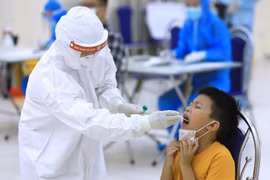 Nhân viên y tế của quận Cầu Giấy, Hà Nội tiến hành lấy mẫu dịch hầu họng để xét nghiệm bằng phương pháp RT-PCR của người dân từ Đà Nẵng trở về. (Ảnh: Thành Đạt/TTXVN)