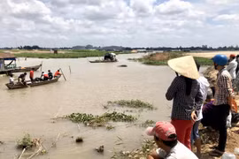 Lực lượng chức năng tỉnh An Giang tổ chức tìm kiếm hai em Th. và T. tại khu vực rạch Tầm Bót (giáp sông Hậu) nơi gần điểm phát hiện dép và quần áo của hai em ở trên bờ. (Ảnh: Công Mạo/TTXVN)