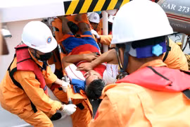 Lực lượng cứu hộ đưa thuyền viên về bờ. (Ảnh: Trần Hoàng Ngọc/TTXVN)