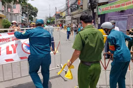 Lực lượng chức năng dỡ bỏ phong tỏa tuyến đường Hồ Văn Đại sau thời gian cách ly 14 ngày. (Ảnh: Lê Xuân/TTXVN)
