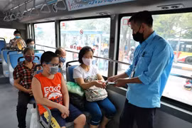 Hành khách và nhân viên xe buýt đều đeo khẩu trang. (Ảnh: Danh Lam/TTXVN)