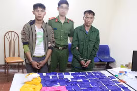 Hai đối tượng và tang vật tại cơ quan Công an. (Ảnh: TTXVN phát)