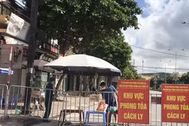 Người dân trong khu vực phong tỏa trên phố Ngô Quyền (Hải Dương) nhận thực phẩm tiếp tế tại hàng rào cách ly ngày 16/8. (Ảnh: Mạnh Minh/TTXVN)
