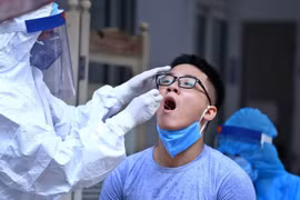 Nhân viên y tế lấy mẫu dịch hầu họng để xét nghiệm bằng phương pháp RT-PCR. (Ảnh: Minh Quyết/TTXVN)