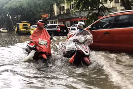 Ôtô, xe máy lưu thông trong biển nước do mưa lớn tại ngã tư Phan Bội Châu-Lý Thường Kiệt. (Ảnh: Lâm Khánh/TTXVN)
