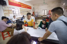 Cán bộ ngành Tài nguyên và Môi trường làm thủ tục cho người dân trong quy trình kiểm kê đất đai và lập bản đồ hiện trạng sử dụng đất. (Ảnh: Trọng Đạt/TTXVN)