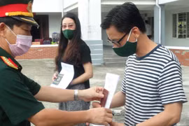 Đại tá Nguyễn Hữu Nghĩa, Phó Chỉ huy trưởng Bộ Chỉ huy Quân sự tỉnh Quảng Nam trao quyết định hoàn thành nhiệm vụ cách ly y tế tập trung cho công dân. (Ảnh: Hữu Trung/TTXVN)