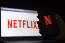 Biểu tượng Netflix trên màn hình máy tính và điện thoại di động ở Arlington, Virginia, Mỹ. (Ảnh: AFP/TTXVN)