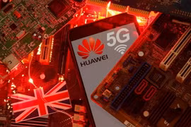 Cờ Anh và điện thoại thông minh có logo mạng Huawei và 5G. (Nguồn: Reuters)