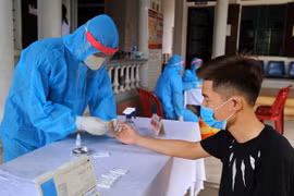 Các cán bộ y tế tiến hành xét nghiệm cho người dân từ vùng có dịch trở về. (Ảnh: Hồ Cầu/TXVN)
